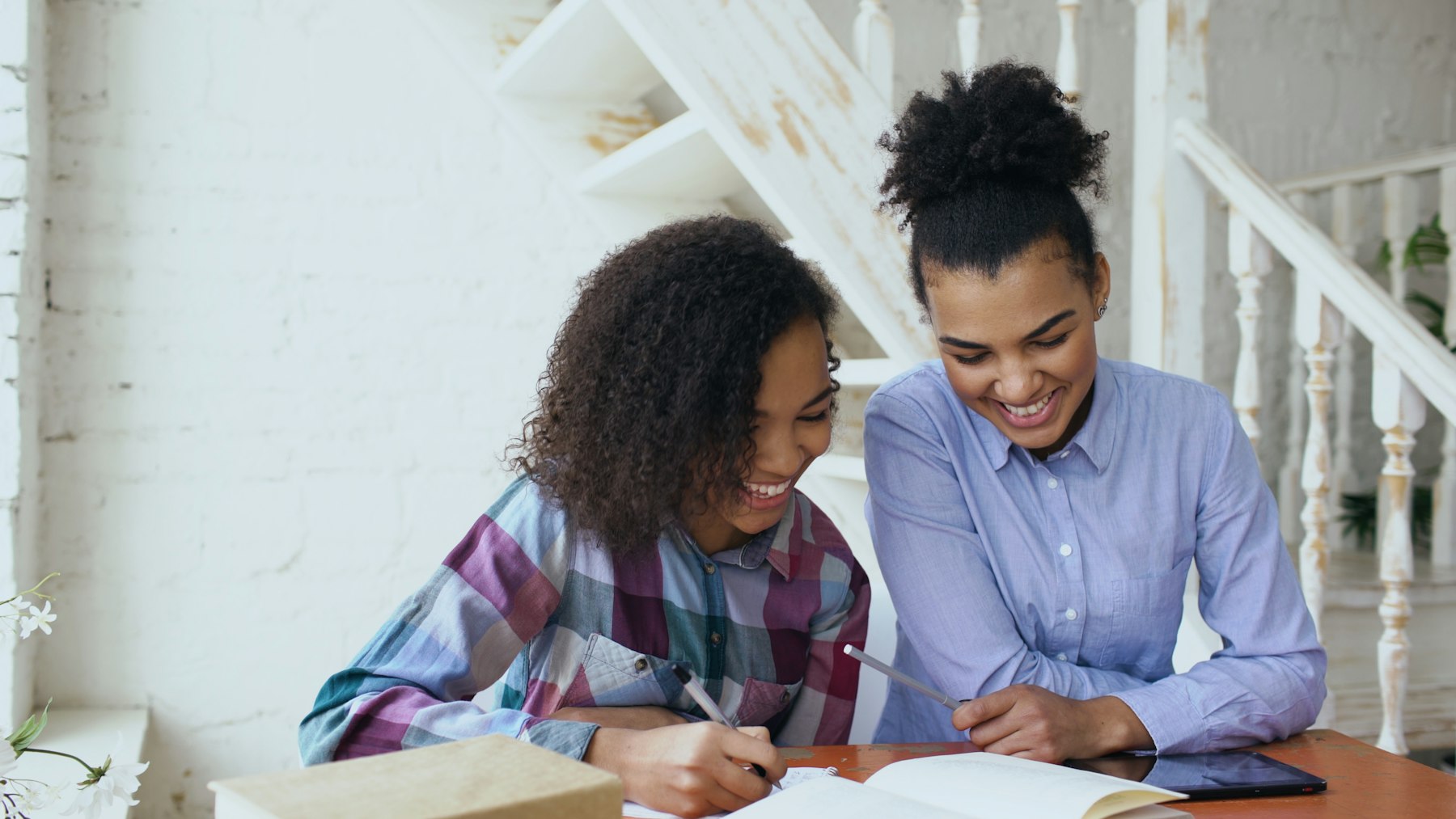A tutor and a student laughing over their work